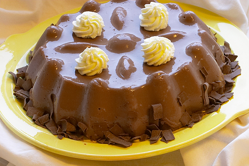 Lekkere chocoladepudding gedecoreerd met vlokken en slagroom